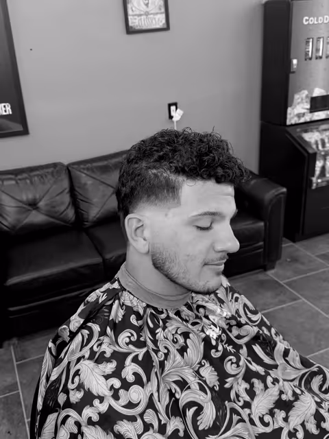 Coupe bouclée avec taper et barbe légère par Youssef Ouda